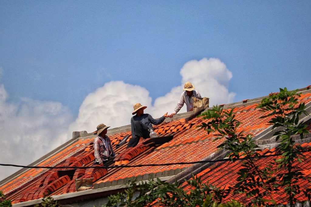 Dakdekker in Hoorn voert onderhoud uit aan een pannendak met gereedschap