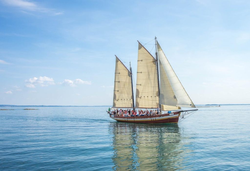 Groep zeilers geniet van diversiteit in zeilervaringen op het water met meerdere zeilboten